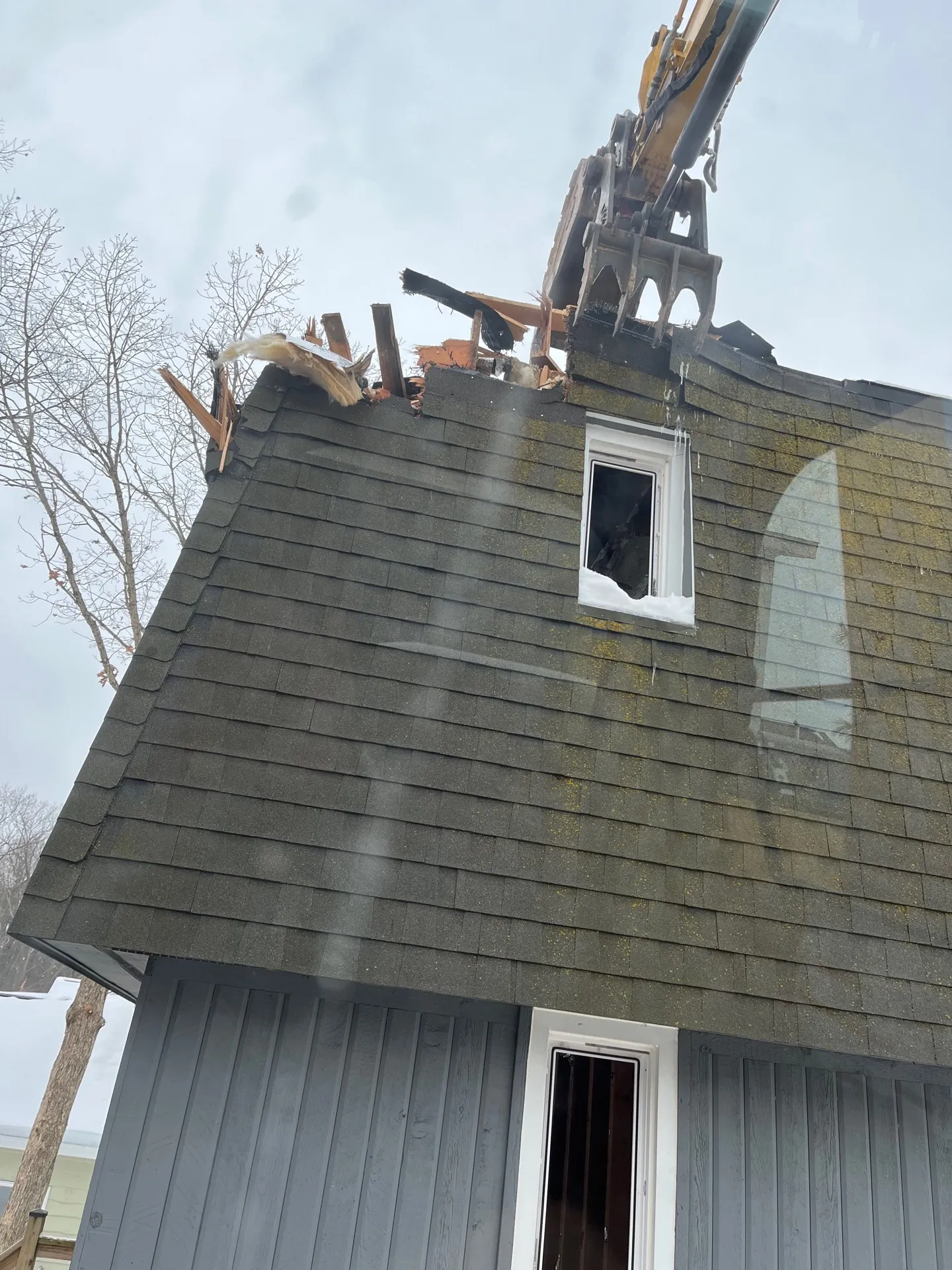 Storm-damaged Kalamazoo home with missing roof and siding before cleanup and excavation
